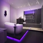 Grau gefliestes Bad mit violettem LED und freistehender Badewanne