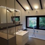 Beige gefliestes Bad mit modernen weißen Sanitäranlagen