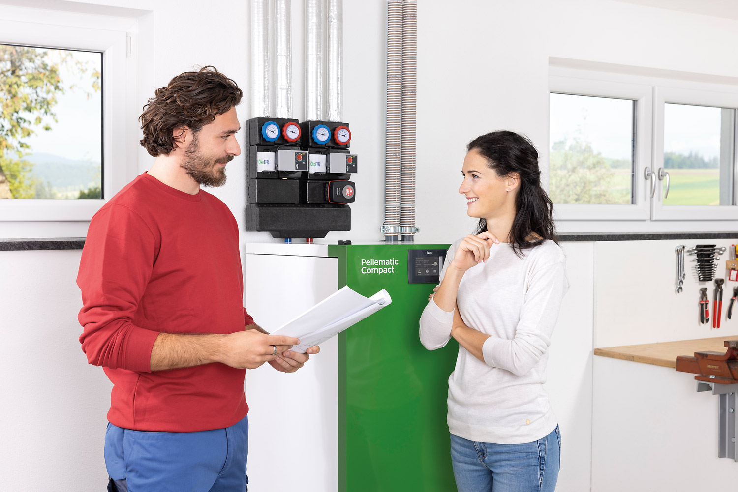 Pellematic Compact mit Installateur und Kundin